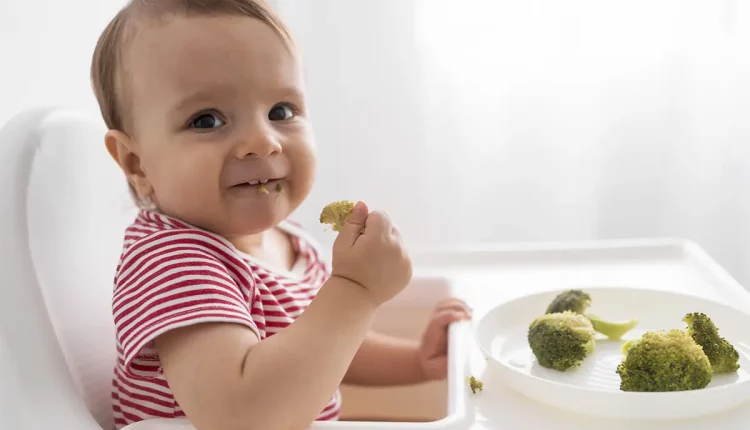 bebe comendo com as mãos